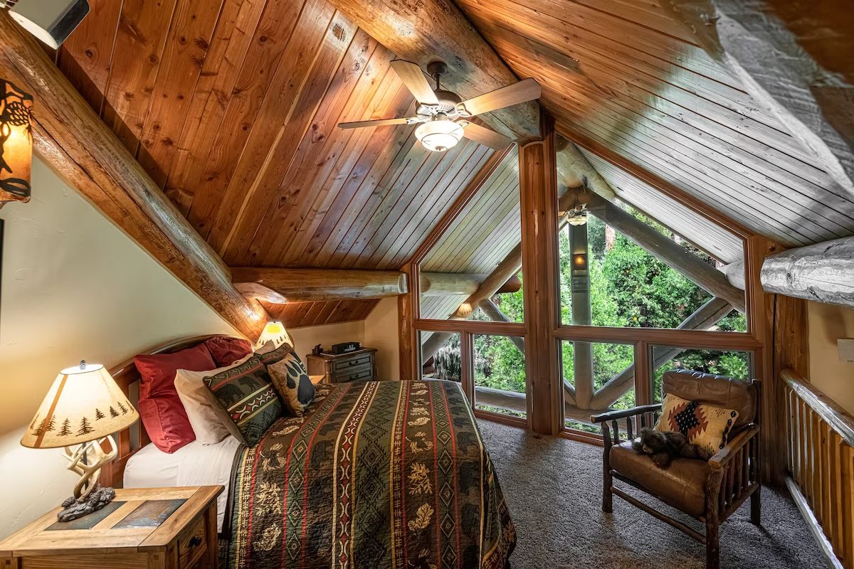 A bedroom with a bed, chair and window.