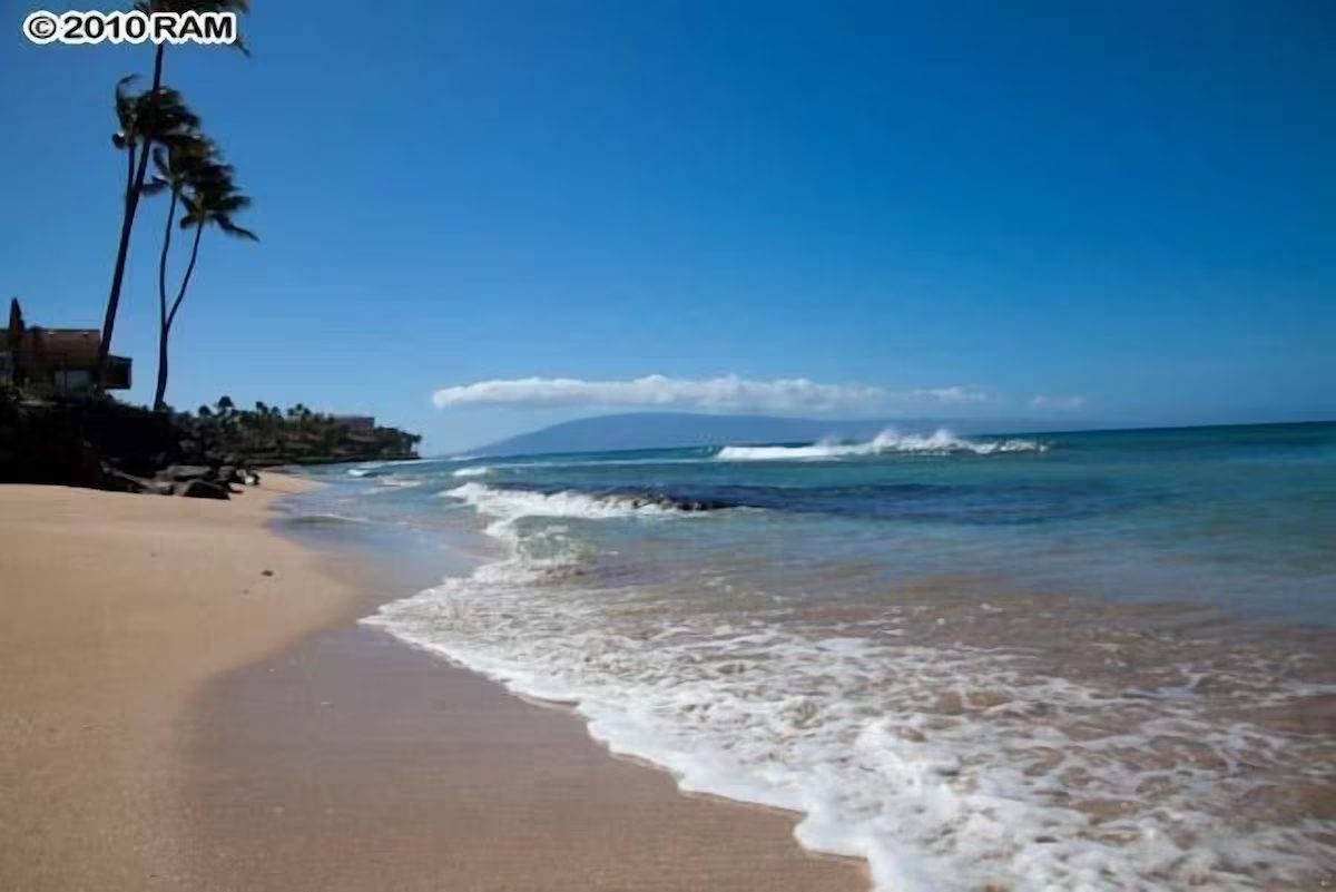 A beach with waves coming in from the ocean.