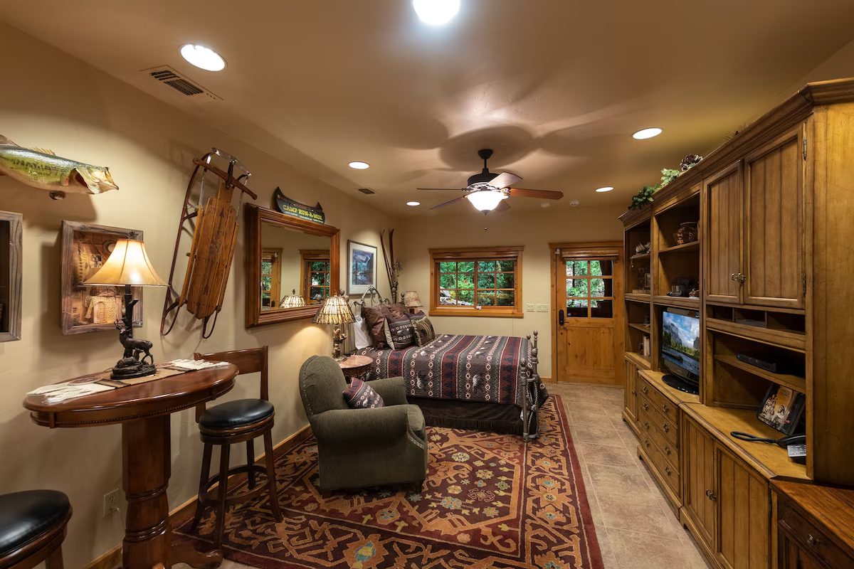 A room with a bed, chair and television.