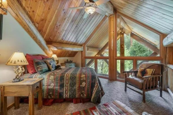 A bedroom with a bed, chair and window.