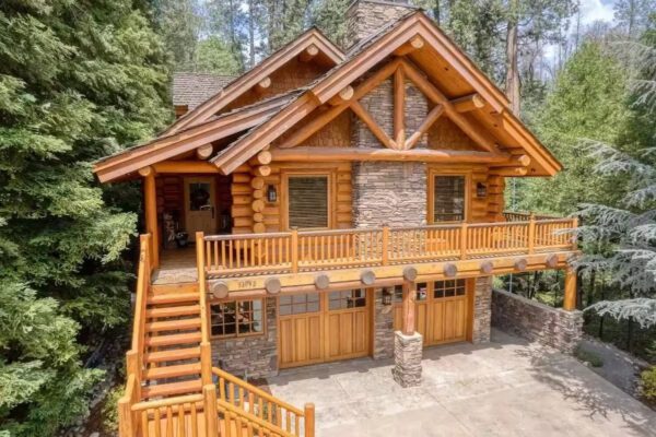 A log cabin with stairs leading to the front of it.