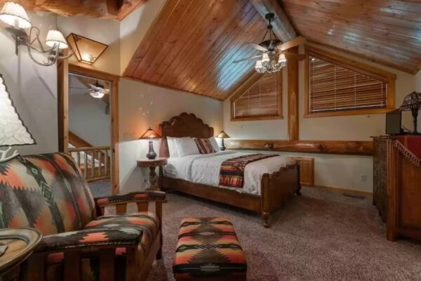 A bedroom with wooden walls and ceiling