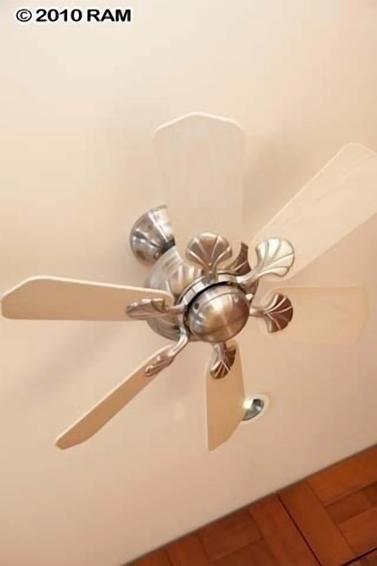 A ceiling fan with four blades on the top of it.