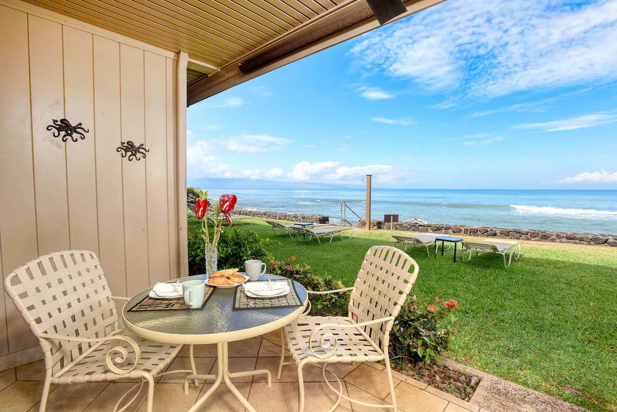 A table and chairs on the patio of an ocean front home.