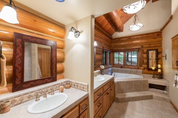 A bathroom with two sinks and a tub.