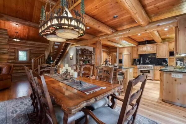 A large wooden table with chairs and lights on top of it.