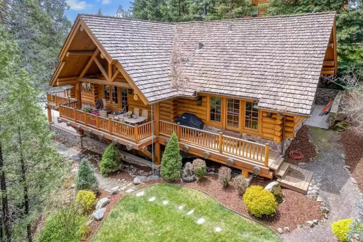 A large log house with a deck and patio area.