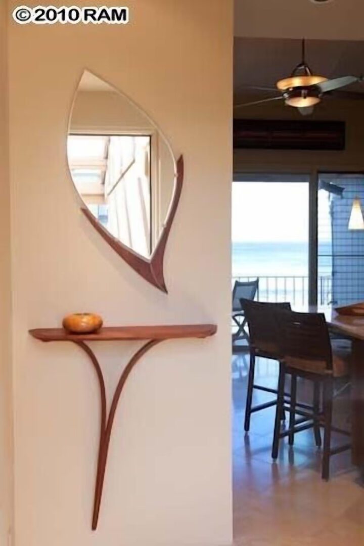 A mirror and shelf in the corner of a room.