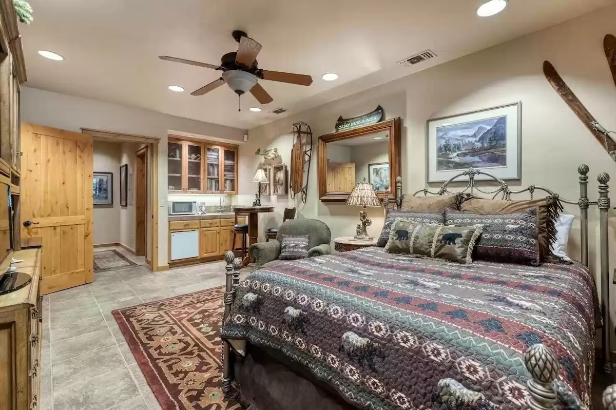 A bedroom with a bed, dresser and mirror.