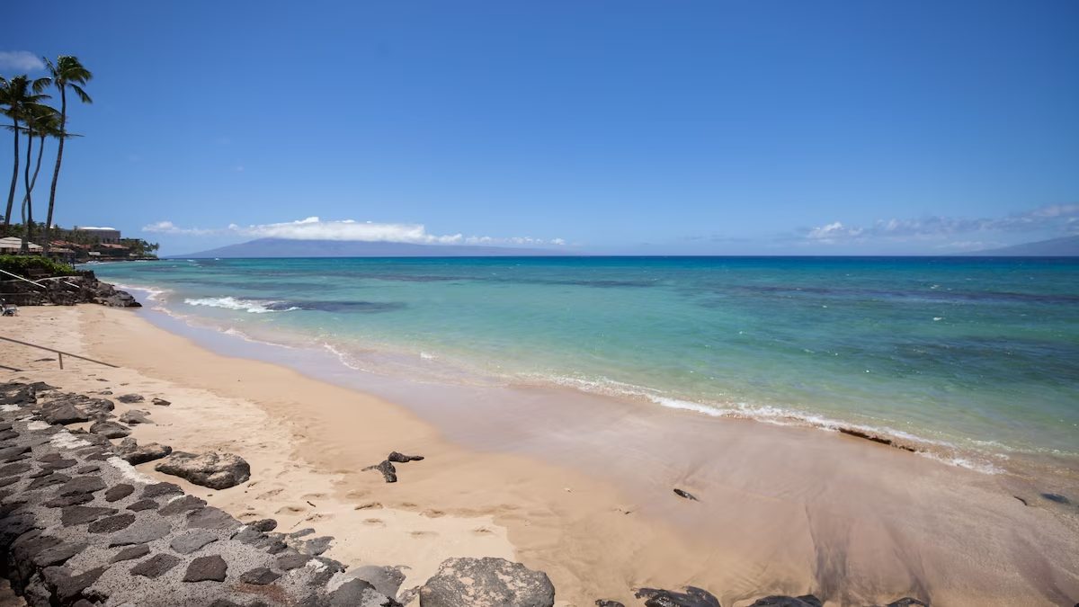 A beach with waves coming in from the ocean.