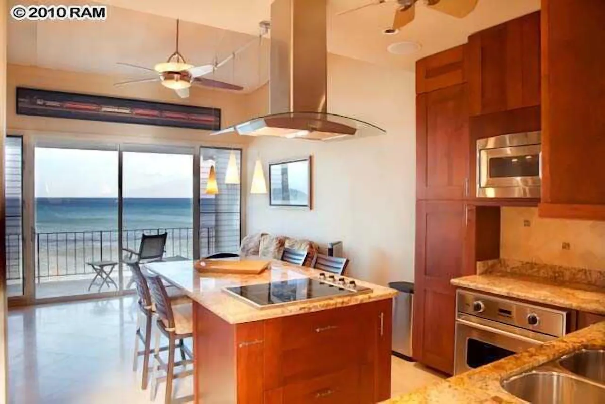 A kitchen with a large island and a view of the ocean.