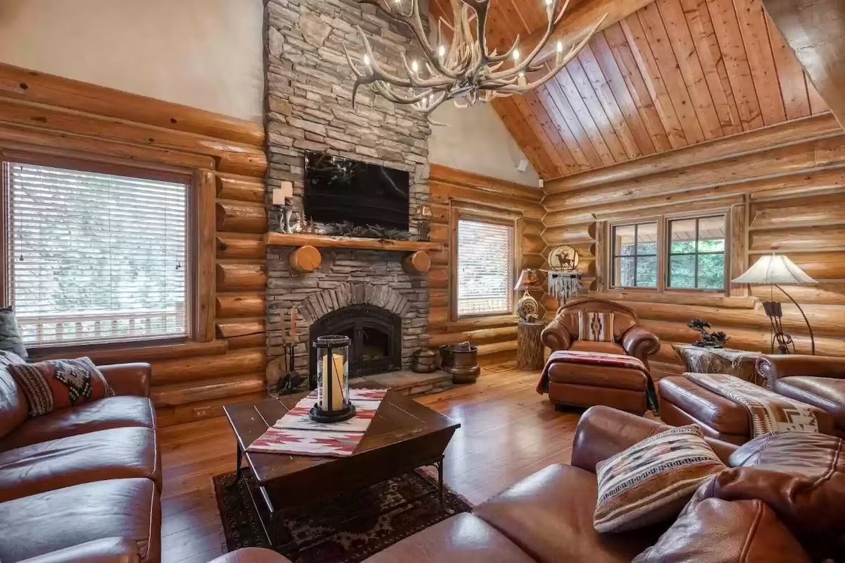 A living room with a fireplace and wooden walls