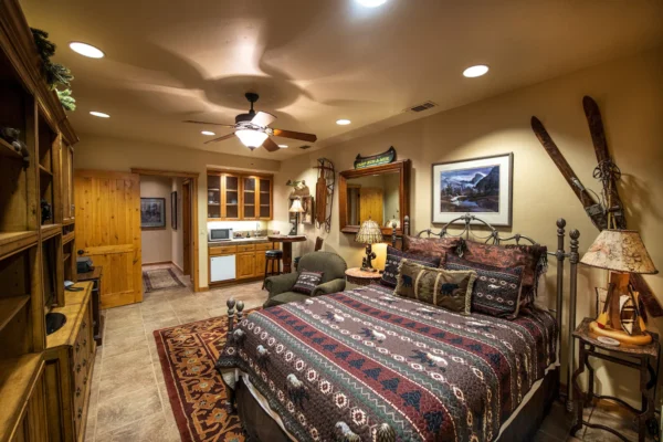 A bedroom with a bed, chair and dresser.