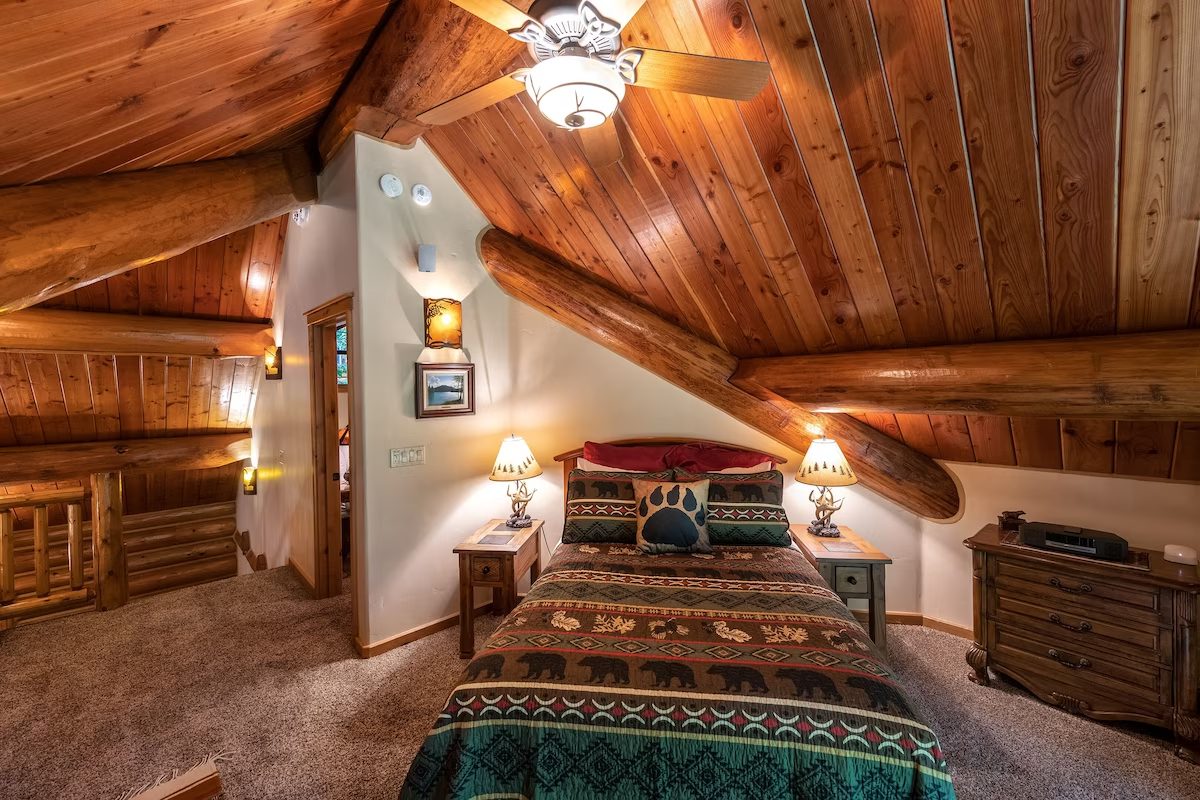 A bedroom with a bed, ceiling fan and lights.