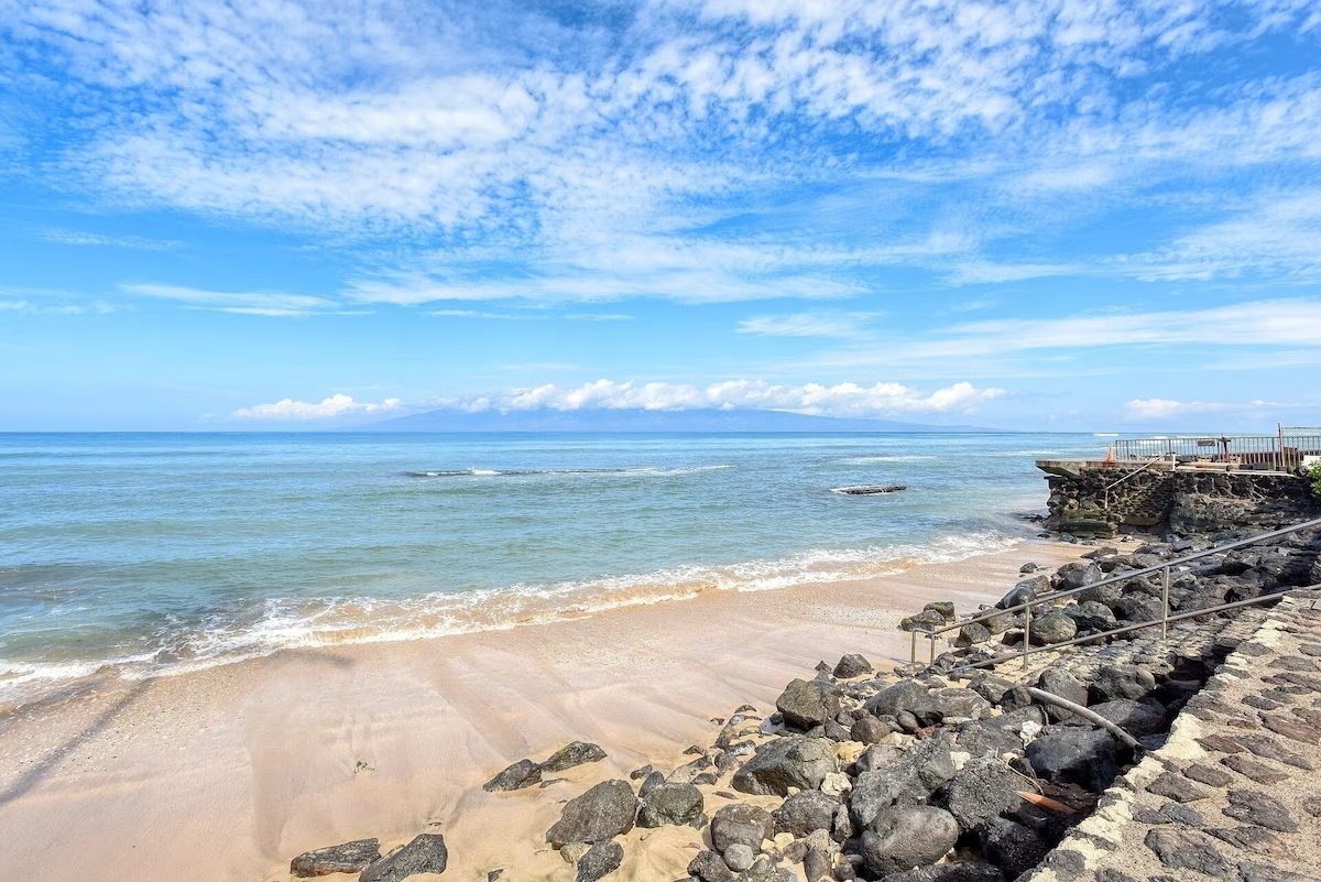 A beach with rocks and water on the shore.