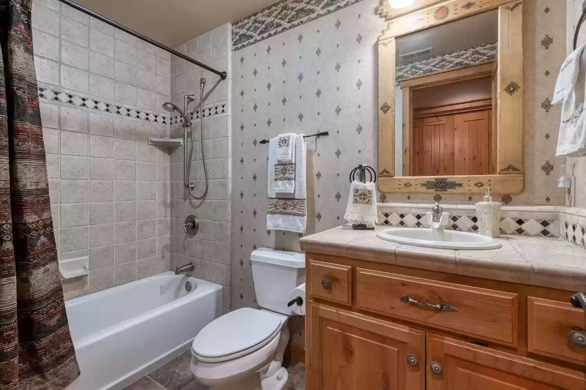 A bathroom with a toilet, sink and bathtub.