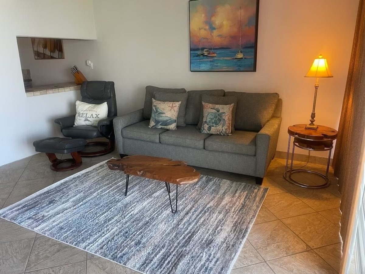 A living room with a couch, chair and table.