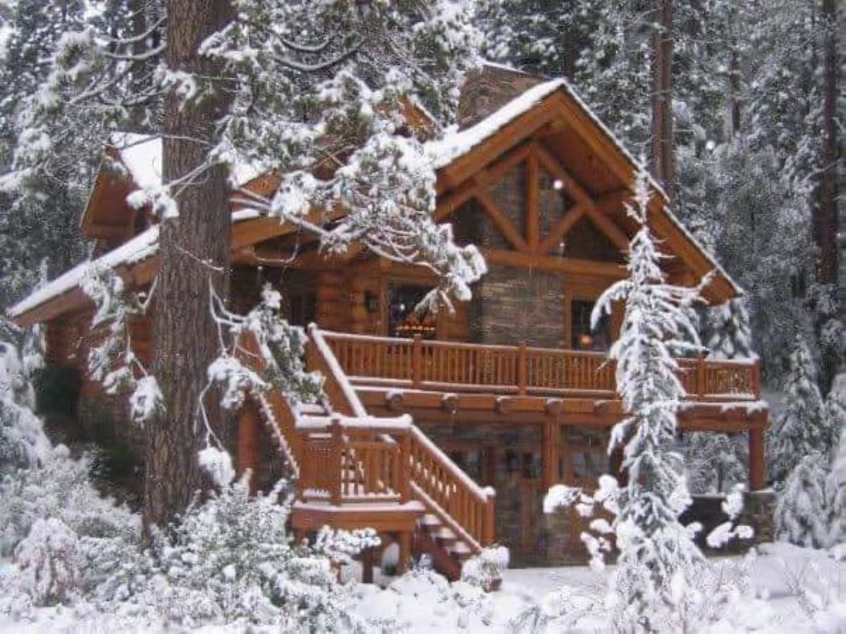 A log cabin in the woods with snow on it.