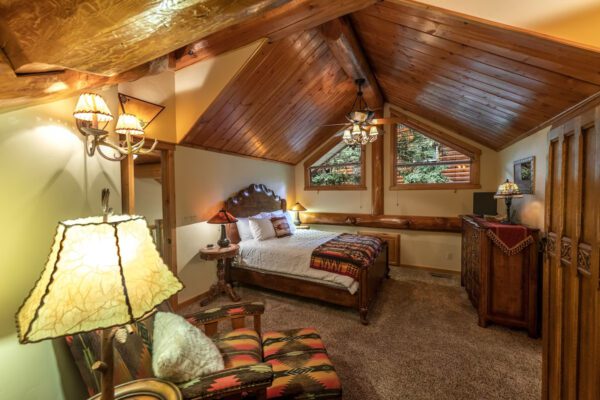 A bedroom with a bed, chair and television.