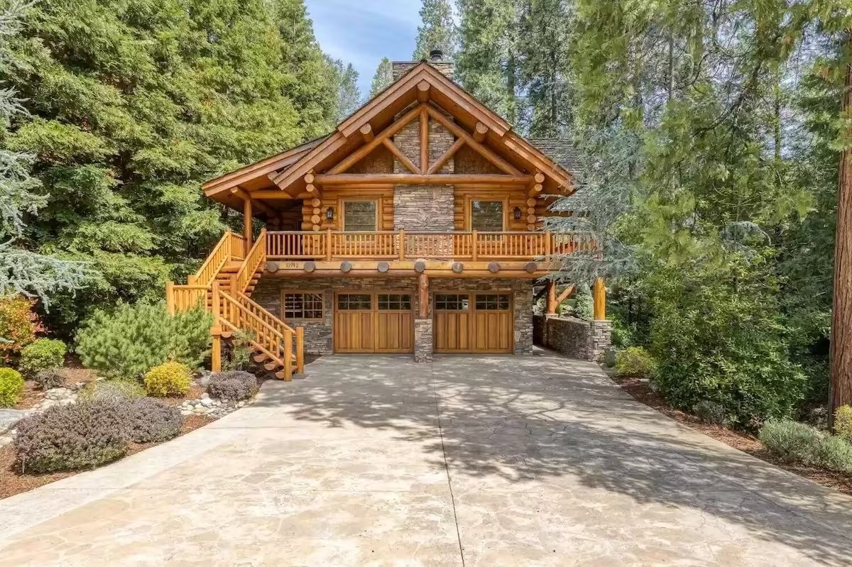 A large log cabin with two garage doors.