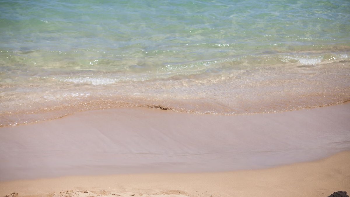 A beach with waves and sand on it