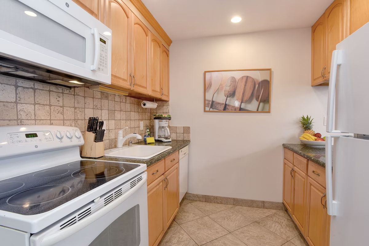 A kitchen with wooden cabinets and white appliances.