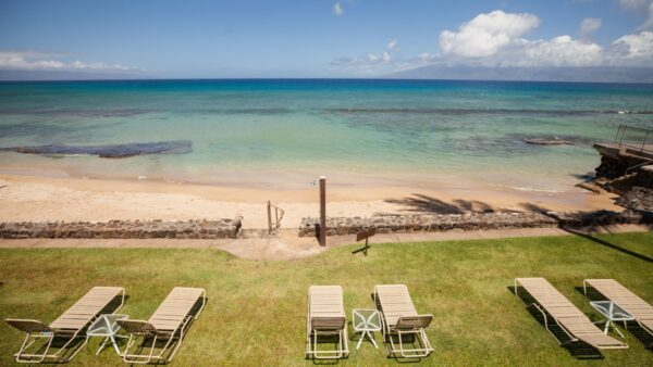 A view of the beach from above with lawn chairs.