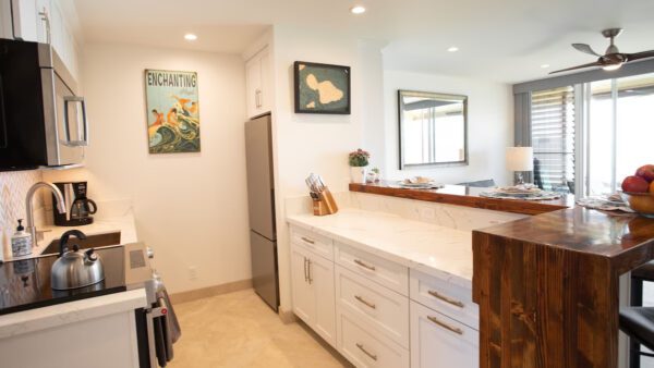 A kitchen with white cabinets and a refrigerator.