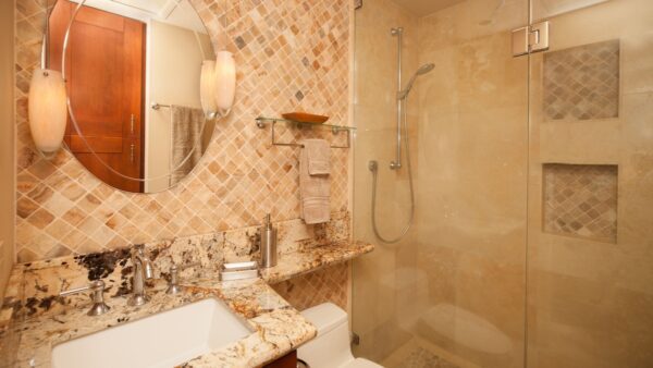 A bathroom with marble counter tops and beige tile.