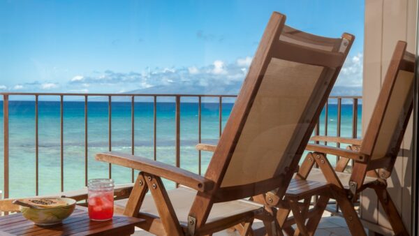 A wooden chair on the side of a balcony.