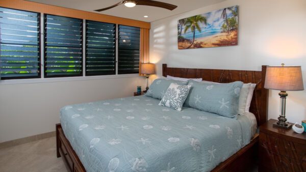 A bedroom with a bed, nightstand and window.