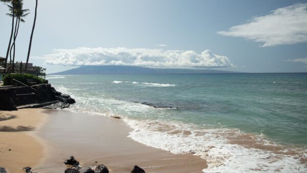 A beach with waves coming in from the ocean.