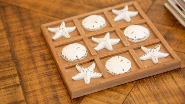 A wooden board with sand dollars and shells on it.