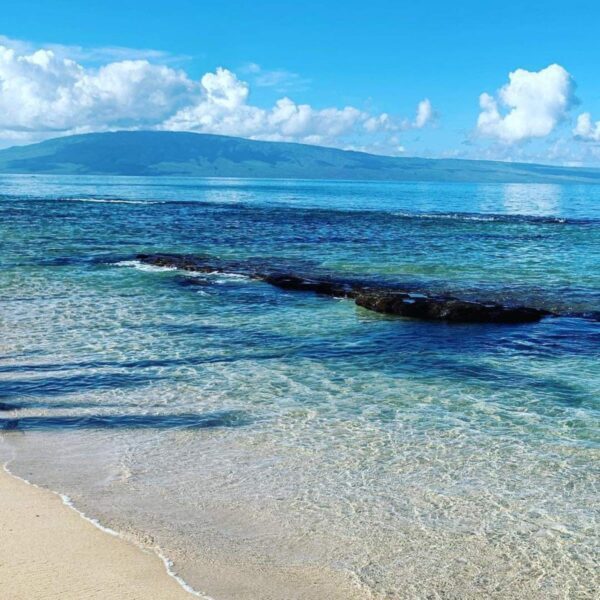 A beach with waves coming in from the ocean.