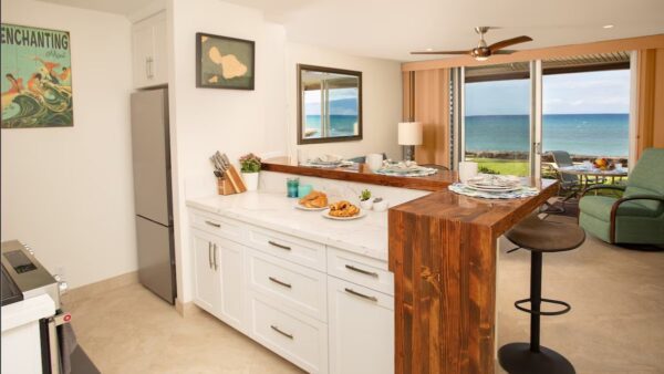 A kitchen with a view of the ocean and a breakfast bar.