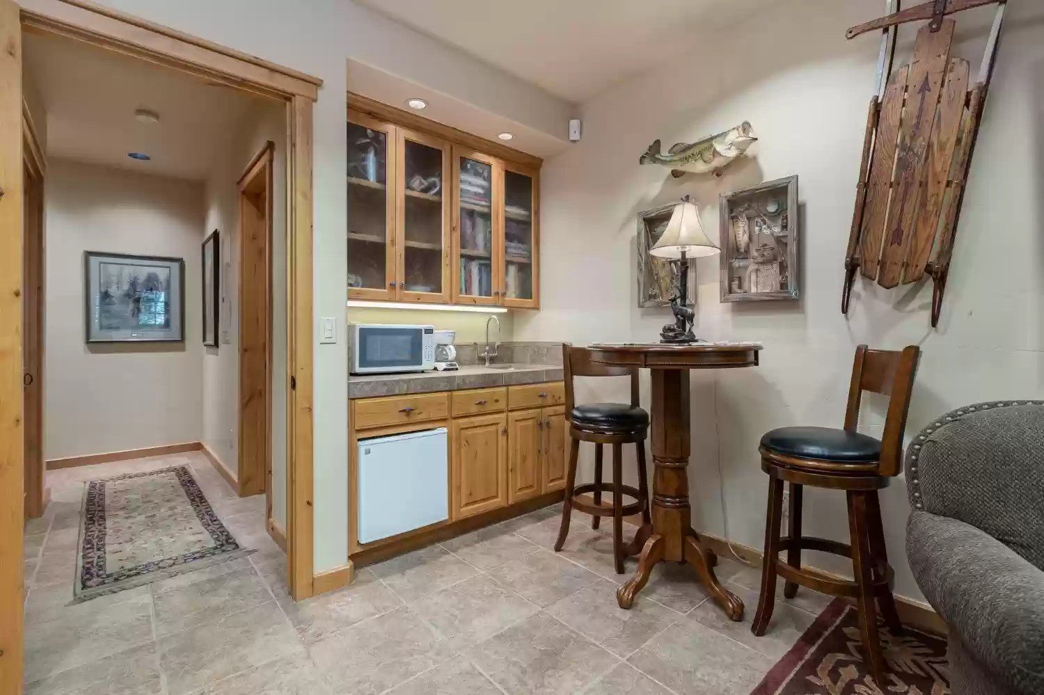 A kitchen with a table and chairs, microwave, refrigerator.