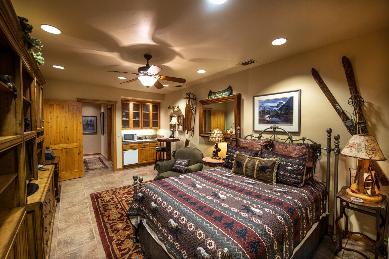 A bedroom with a bed, dresser and mirror.