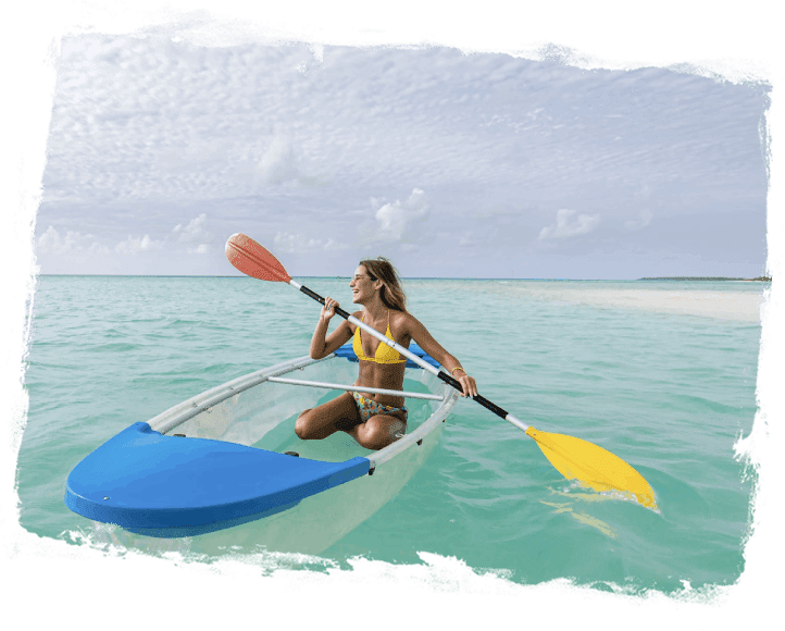 A woman in yellow bikini paddling on a clear kayak.