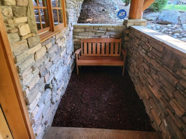 A bench in the middle of a stone wall.